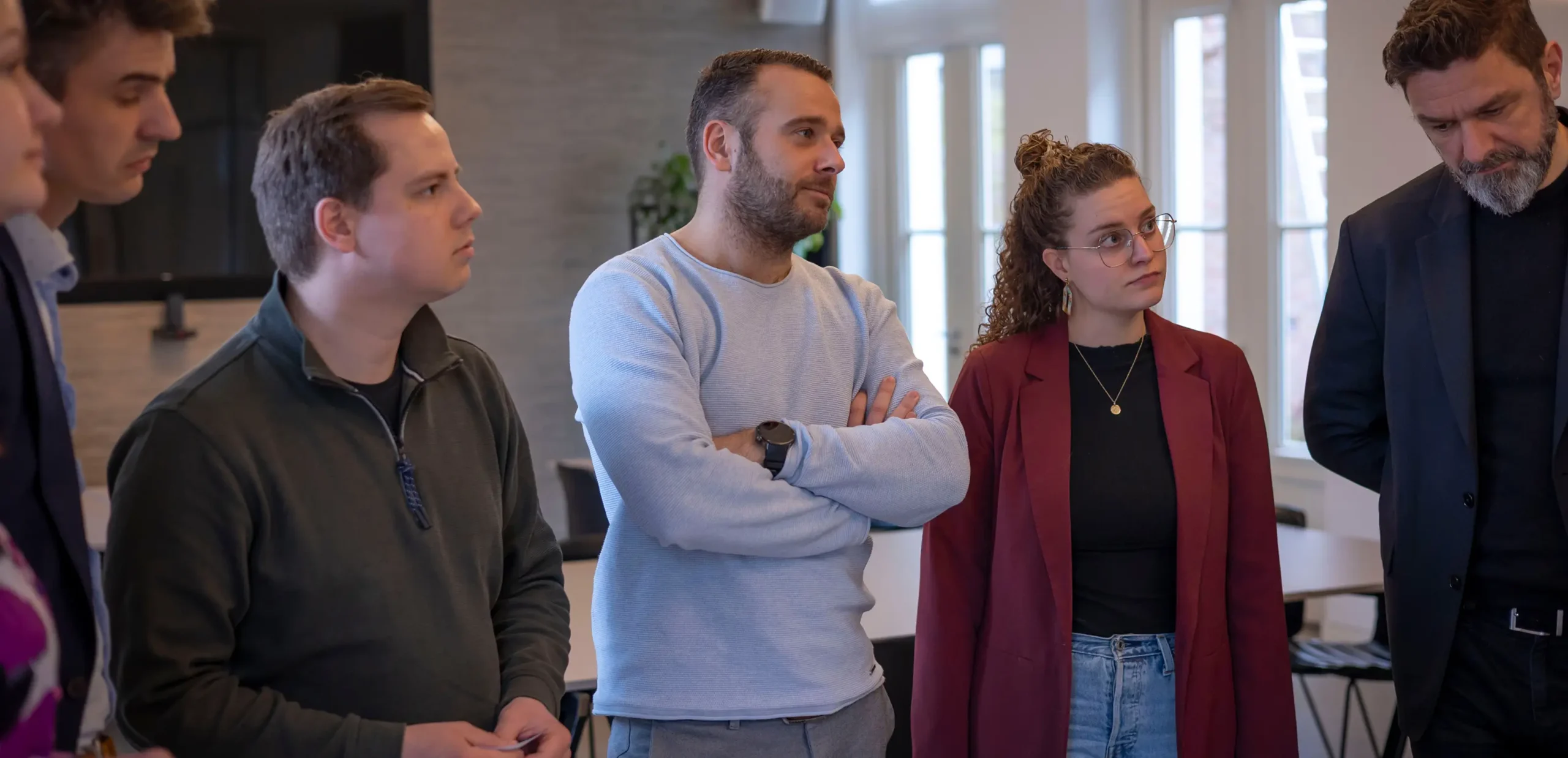 6 people standing and listening/paying attention
