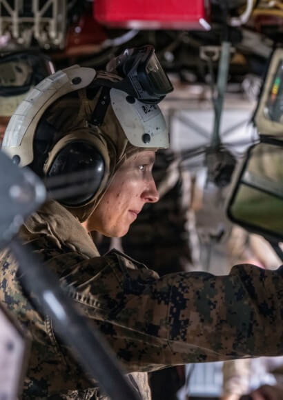 Soldier wearing headset works inside a vehicle light